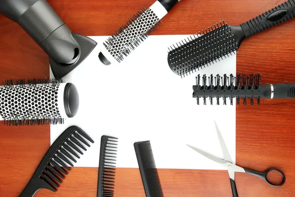 Comb brushes, hairdryer and cutting shears,on wooden background — Stock Photo, Image