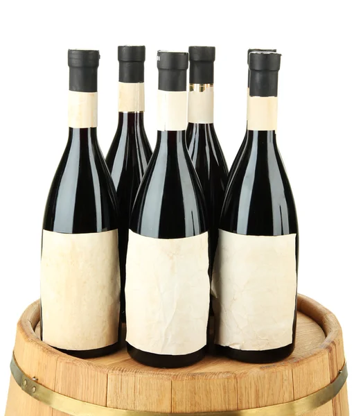 Wine bottles on wooden barrel, isolated on white — Stock Photo, Image