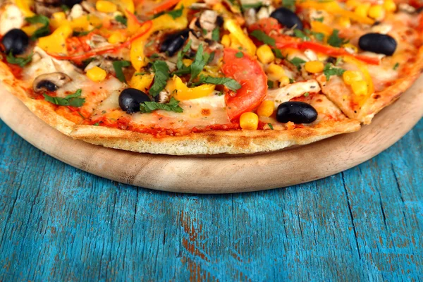 Tasty pizza on blue wooden table close-up — Stock Photo, Image