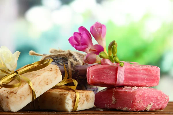 Natural handmade soap, on wooden table, on green background — Stock Photo, Image