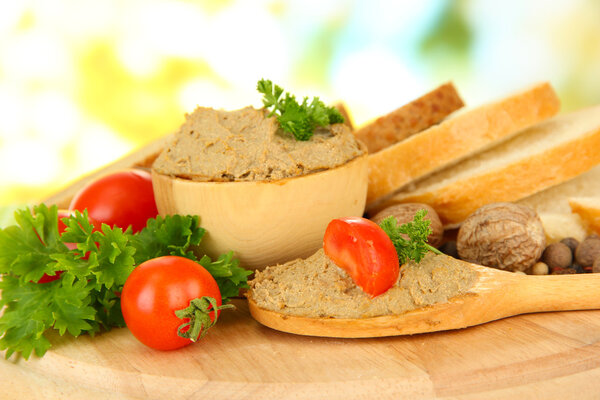 Состав свежего паштета, помидоров и хлеба, на ярком фоне
