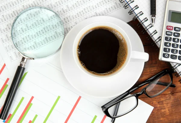 Taza de café en la mesa de trabajo cubierta con documentos de cerca — Foto de Stock
