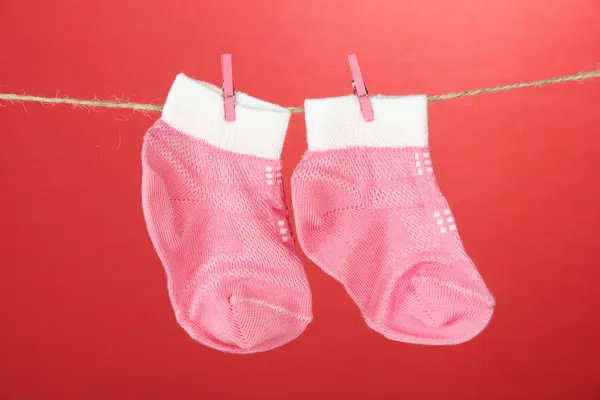 Chaussettes colorées suspendues sur corde à linge, sur fond de couleur — Photo