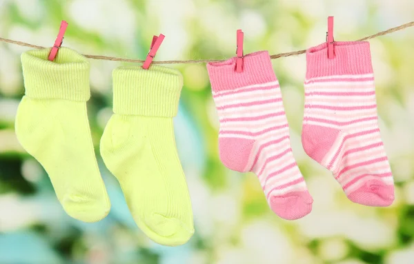 Barevné ponožky na prádelní šňůru, na světlé pozadí — Stock fotografie