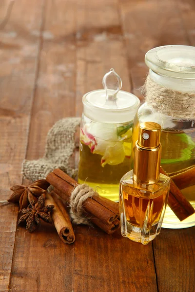 Botol dengan bahan-bahan untuk parfum di latar belakang kayu — Stok Foto