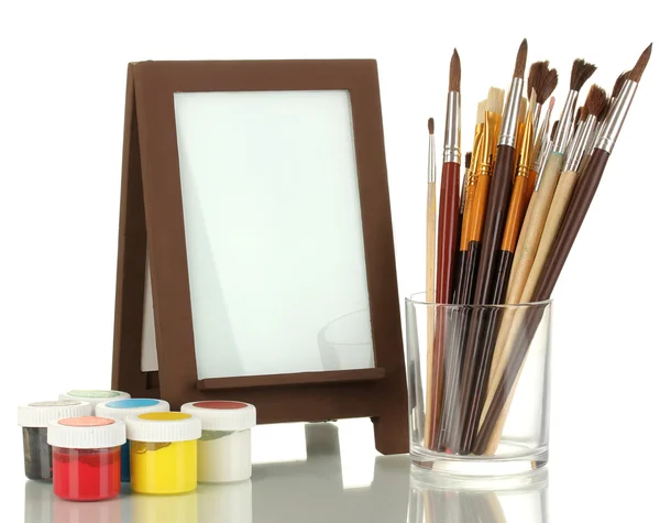 Photo frame as easel with artist's tools isolated on white — Stock Photo, Image