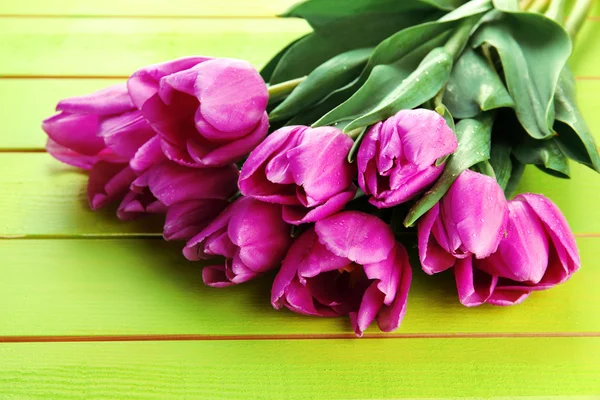 Piękny bukiet tulipanów fioletowy na zielonym tle drewniane — Zdjęcie stockowe