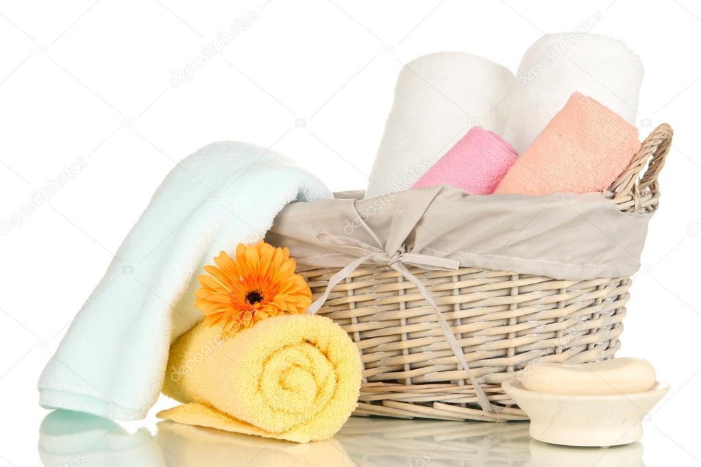 Bathroom towels folded in wicker basket isolated on white