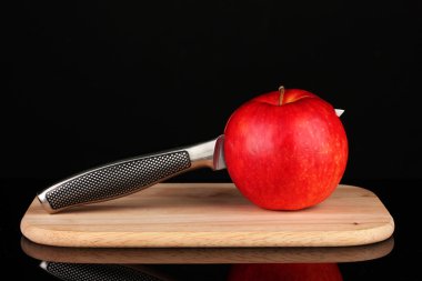 Kırmızı elma ve siyah izole kesme tahtası üzerinde bıçak