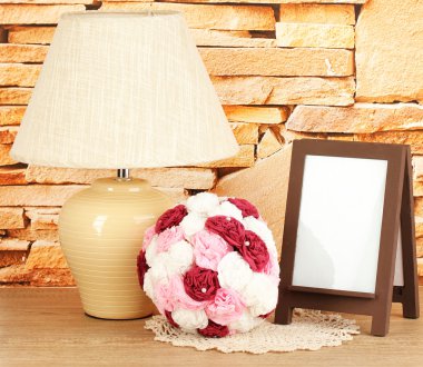 kahverengi fotoğraf çerçevesi ve taş duvar zemin üzerine ahşap masa lambası