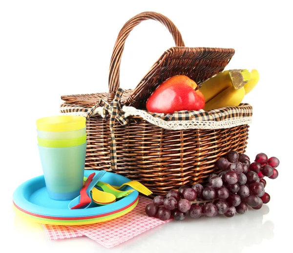 Picnic basket with fruits and tableware isolated on white — Stock Photo, Image