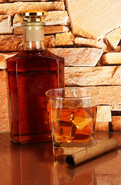 Bouteille et verre de whisky et cigare sur fond de mur de briques — Photo