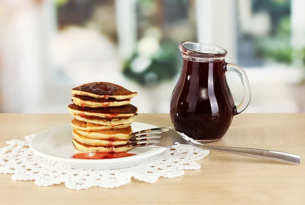Sweet pancakes on plate with jam on table in kitchen — Stock Photo, Image