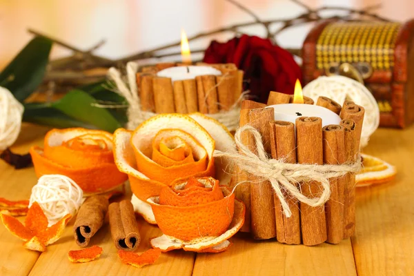 Rosa decorativa da casca de laranja seca e velas em chamas na mesa de madeira — Fotografia de Stock