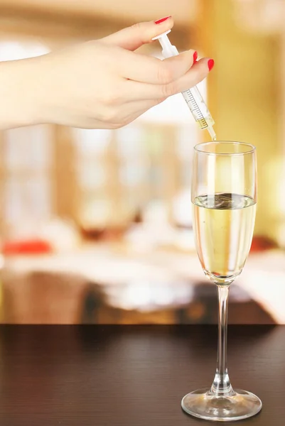 Giet iets in glas met drankje op houten tafel op kamer achtergrond — Stockfoto