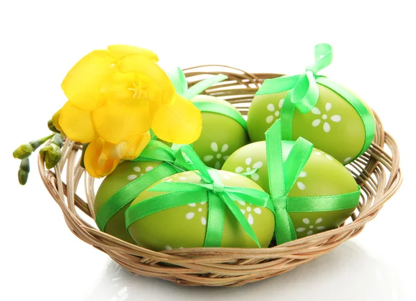 Světlé velikonoční vajíčka s luky v koši, izolované na bílém — Stock fotografie