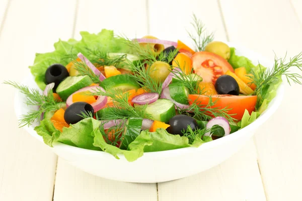 Insalata fresca in piatto su tavolo di legno — Foto Stock