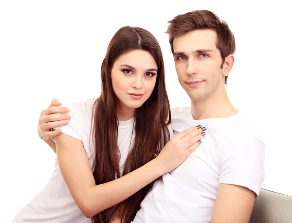 Young couple sitting together isolated on white — Stock Photo, Image