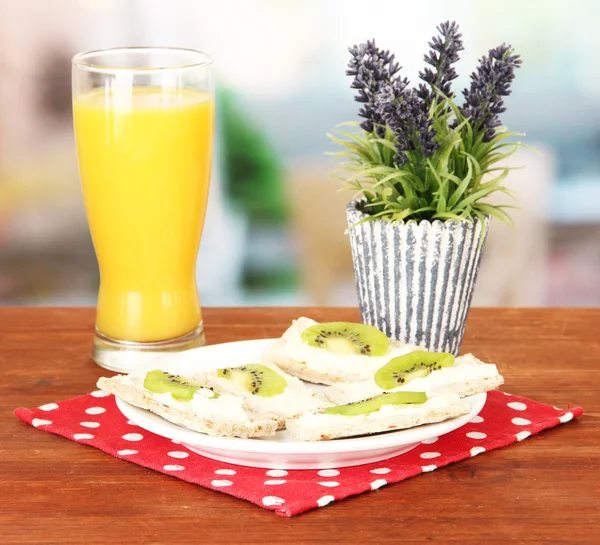 Tasty canapes with cheese and kiwi, on color plate, on bright background — Stock Photo, Image