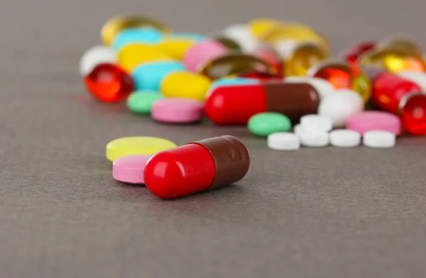 Variedade de comprimidos, comprimidos e cápsulas sobre fundo cinzento — Fotografia de Stock
