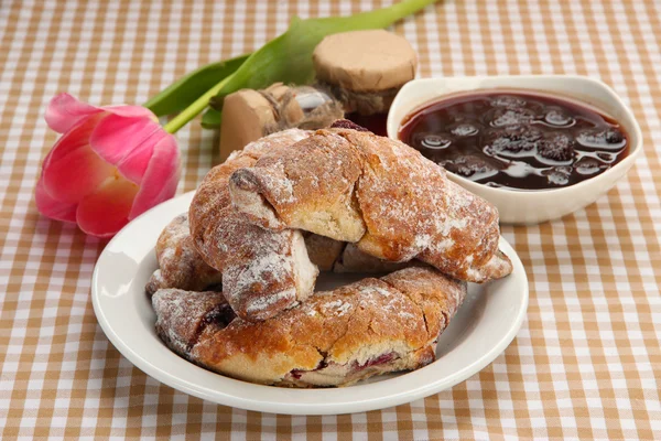 Taste croissants on plate and jam on tableclot — Stock Photo, Image