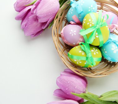 sepet ve laleler, üzerinde beyaz izole parlak Paskalya yumurtaları