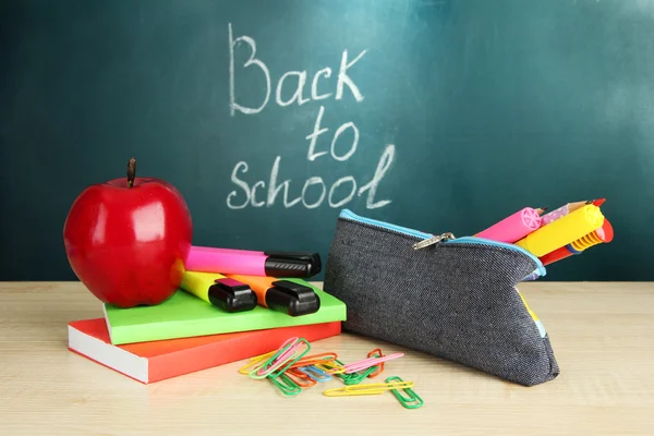 Voltar à escola - quadro-negro com caixa de lápis e equipamento escolar na mesa — Fotografia de Stock