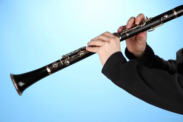 Músico tocando no clarinete no fundo azul — Fotografia de Stock