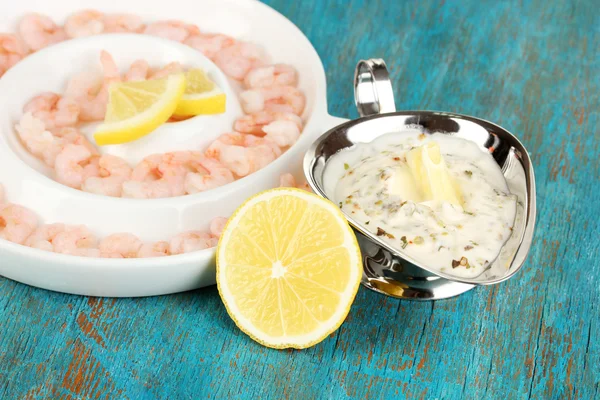 Shrimps with lemon on plate on blue wooden table close-up — Stock Photo, Image