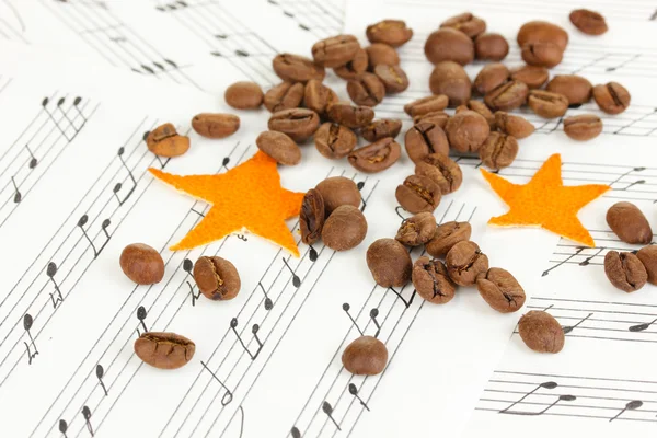 Decorative stars from dry orange peel with coffee beans on musical notes — Stock Photo, Image