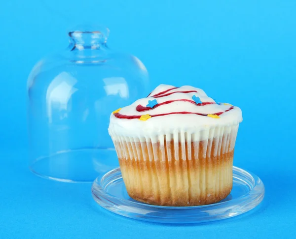 Cupcake på tefat med glaskupa, på färgbakgrund — Stockfoto