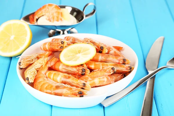 Shrimps with lemon on plate on wooden table close-up — Stock Photo, Image