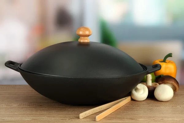 Czarny pan woka i warzywa na stole w kuchni, z bliska — Zdjęcie stockowe