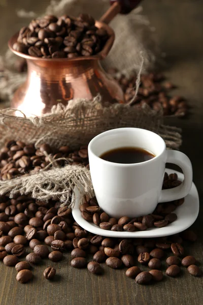 Чашка кофе и горшок на деревянном фоне — стоковое фото