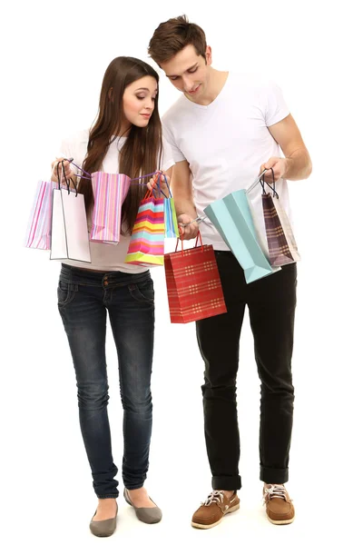 Jeune couple faisant du shopping et tenant de nombreux sacs isolés sur blanc — Photo