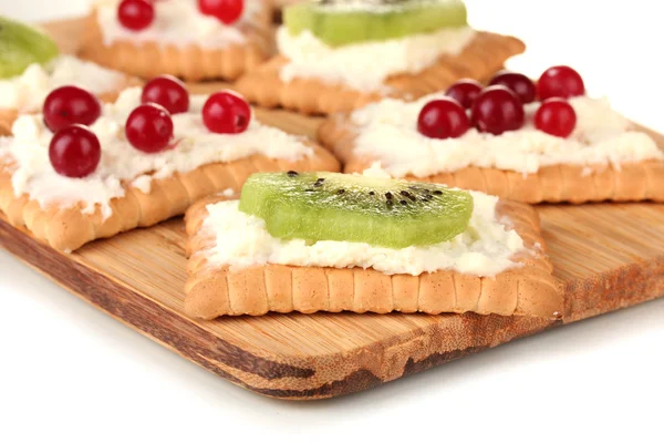 Sabrosos canapés con queso, kiwi y arándano, sobre tabla de cortar, aislados en blanco — Foto de Stock