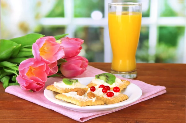 Canapés saborosos com queijo, kiwi e cranberry, amêndoa, na placa de cor, no fundo brilhante — Fotografia de Stock