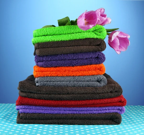 Pile of colorful towels, on blue background — Stock Photo, Image