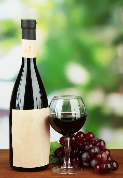 Composition of wine bottle, glass and grape, on bright background — Stock Photo, Image