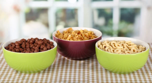 Läcker och hälsosam spannmål i skålar på bord i rummet — Stockfoto