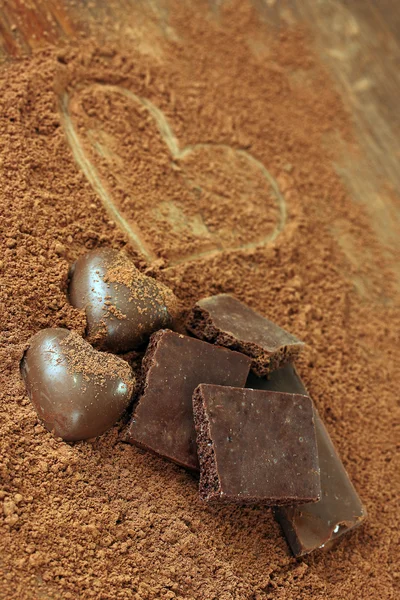Apróra vágott csokoládé és édességek, kakaó, barna háttér — Stock Fotó