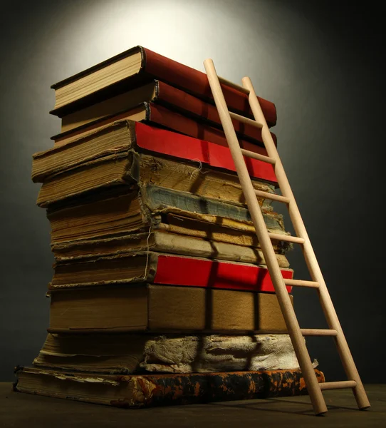 Old books and wooden ladder, on grey background — Stock Photo, Image