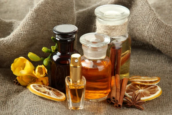 Bottles with ingredients for the perfume on burlap background — Stock Photo, Image