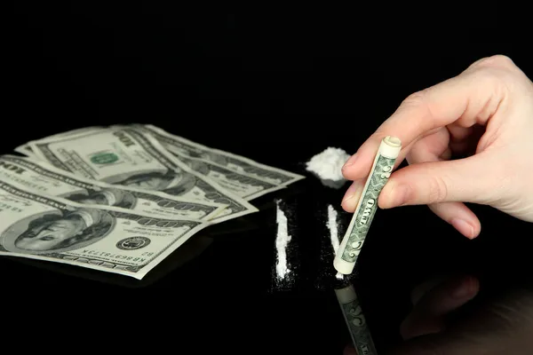 Cocaine drugs lines and female hand holding rolled dollar banknote, close up — Stock Photo, Image