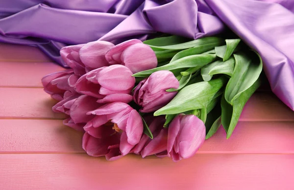 ピンクの木製の背景に紫のチューリップの美しい花束 — ストック写真