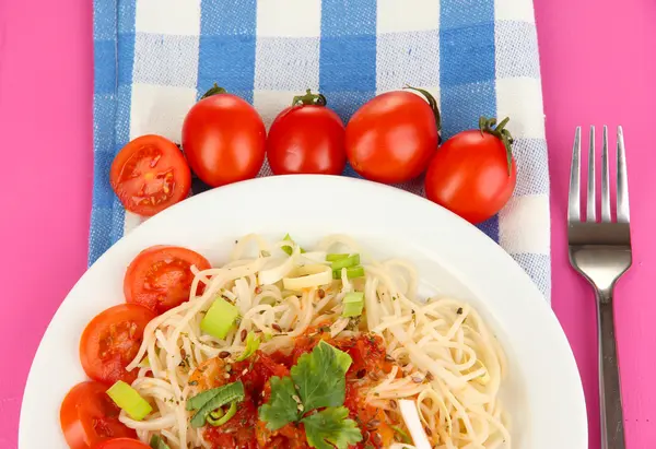 Leckere Spaghetti mit Sauce und Gemüse auf Teller auf Holztisch in Großaufnahme — Stockfoto