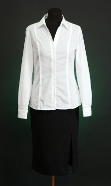 Beyaz bluz ve manken üzerinde koyu renk arka plan üzerinde siyah etek