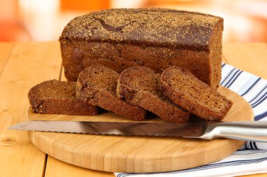 Dilimlenmiş Siyah ekmek ve bıçak Kıyma Kurulu ahşap masa üzerinde kapat