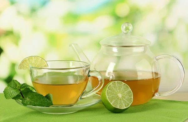 Taza de té con menta y lima sobre la mesa sobre fondo brillante —  Fotos de Stock