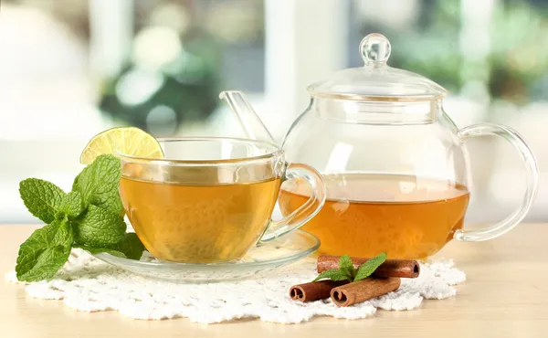 Taza de té con menta, lima y canela en la mesa en la habitación — Foto de Stock